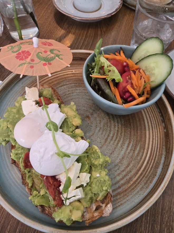 Smashed avocado on toast with poached eggs, feta and a slaw salad